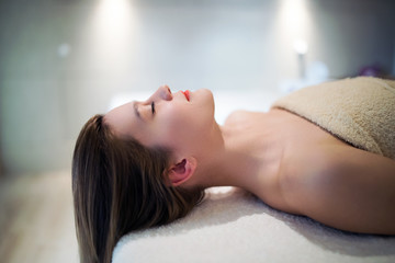 Obraz na płótnie Canvas Beautiful woman relaxing on massage bed