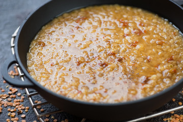 Close-up of a cast-iron pan with indian masoor dal or red lentils soup, selective focus, shallow...