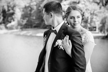 Wedding beautiful couple with good mood kisses on a nature. Love is all you need. Plus size tenderness bride and younger groom