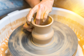 womens hands of a potter creating an earthen jar