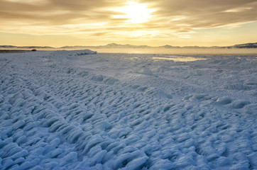 Ice floes floating on the fog water in the lake Baikal. Sunset