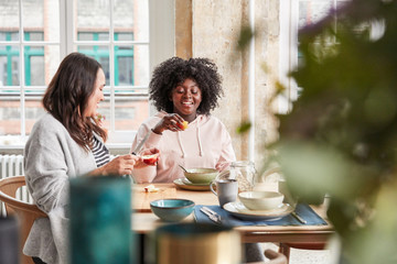 Frauen essen Müsli und Apfel zum Frühstück