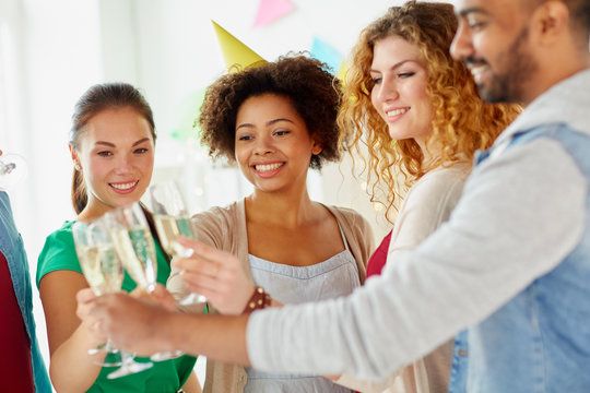 friends clinking glasses of champagne at party