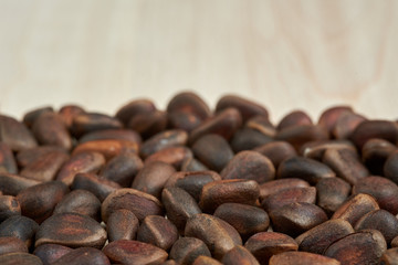 A scattering of pine nuts on the background of boards made of maple.