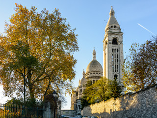 Naklejka premium Back view of the Basilica of the Sacred Heart of Paris at sunrise in autumn with the square steeple in the foreground.