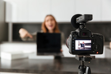 Smiling young girl recording video blog episode