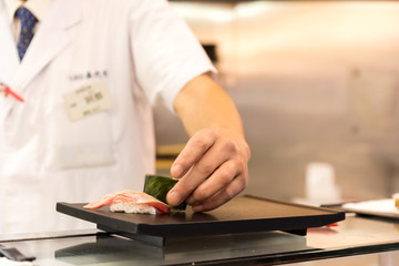Fototapeta na wymiar Chef making Sushi on the plate in a Japanese restaurant.