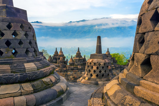 Candi Borobudur in the background of rainforest, morning mist and Sumbing Mountain. Borobudur, Yogyakarta, Jawa, Indonesia.