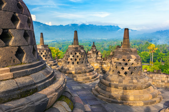 Candi Borobudur in the background of rainforest, morning mist and Sumbing Mountain. Borobudur, Yogyakarta, Jawa, Indonesia.