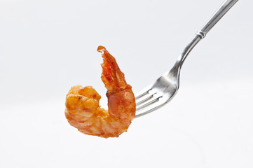 Cooked shrimps on ss fork on white background 