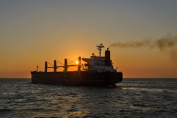 Fototapeta premium Bulker cargo vessel at sunset