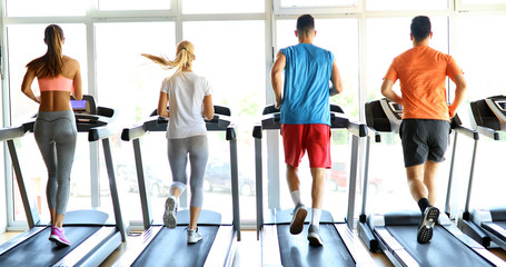 Fototapeta na wymiar Picture of people running on treadmill in gym