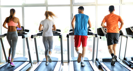Fototapeta na wymiar Group of friends exercising on treadmill machine