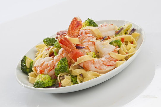 Jumbo Shrimp Pasta with broccoli & Vegetable with cheesy white gravy on white plate with white background 