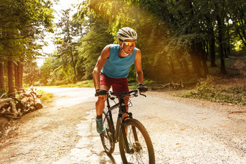 Obraz premium Young man riding a mountain bike on old country road.Spring season.