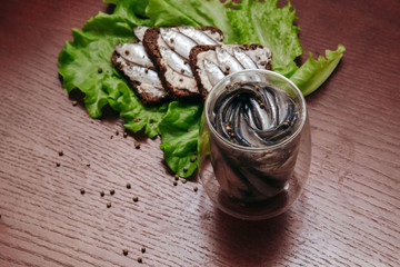 vegetables with sprat in a glass jar on a wood table  