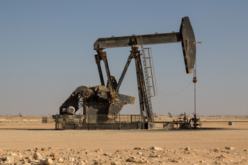 Crude oil drilling well pumping the black gold out of the soil on an oil field of the Sultanate of...