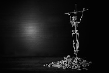 Crucifixion wooden skeleton top on pile of bone by god of death because perpetration of a sin