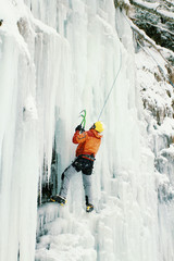 Ice climbing the North Caucasus, man climbing frozen waterfall.