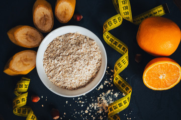 oat flakes for breakfast for slimming with fruit on a dark background