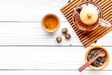 Tea break. Tea pot, cups and tea leaves on white wooden background top view copyspace