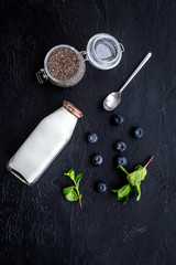 Fototapeta na wymiar Light dessert with chia seeds, yogurt, blueberry and mint. Black background top view