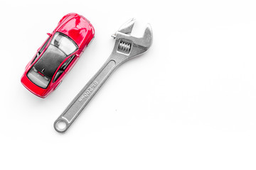 Car repair concept. Wrench near car toys on white background top view copyspace