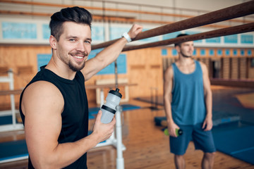 Fototapeta na wymiar two smiling guys in oldschool wooden gym;