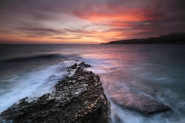 sunset in the bay of cassis, provence, mediterranean sea, with leger spun on the waves