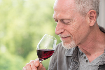 Mature man tasting red wine