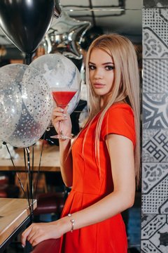 Woman standing in a bar holding a cocktail