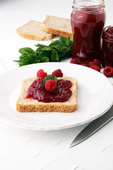 Fresh raspberry jam with toast or bread for breakfast.