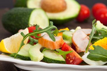 Healthy salad of tomatoes, cucumbers, avocado and chicken breast meat.