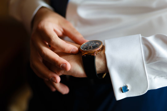 The man hands in the white shirt suits expensive watches at the window. watch with dark dial on the hand of a businessman in a white shirt. Closeup