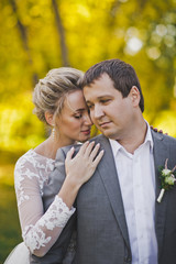 Fototapeta premium The bride hugs the groom on the background of a Sunny forest 50.
