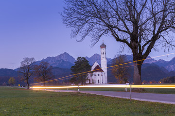 Sunrise on St Coloman Church surrounded by woods.  Schwangau, Fussen, Bavaria, Southwest Bavaria, Germany, Europe.