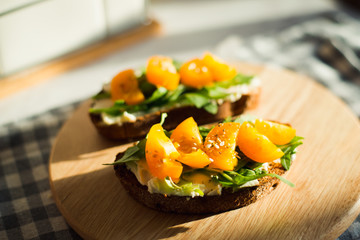 toast with cream cheese, yellow tomatoes and arugula sunlight