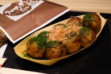 takoyaki, traditional japanese food in wooden paper bowl