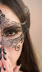 Gorgeous  dark haired woman with black makeup wearing a black carnival mask,bright black lipstick...