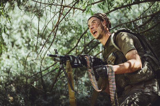 Man in military uniform with machine gun in the woods. military, war and people concept