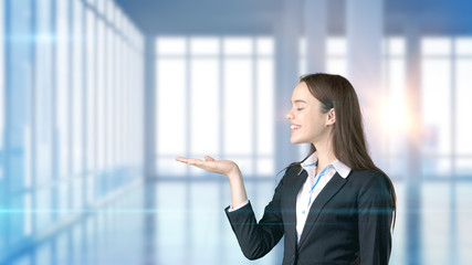 Young beautiful business woman and creative designer standing over blured interior background