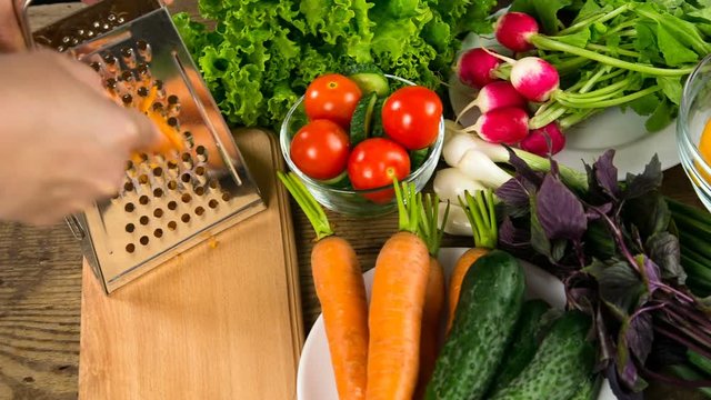 Assortment of vegetables on wooden table with grater