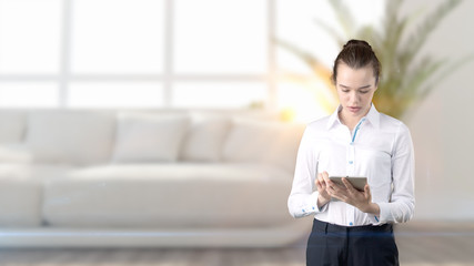 Young beautiful business woman and creative designer standing over blured interior background
