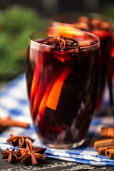 Christmas hot mulled wine in a glass with spices and citrus fruit. Mulled wine with cinnamon, anise and orange. Christmas atmosphere