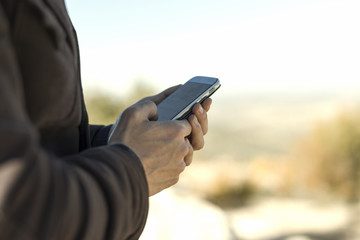 Hands on smartphone sending message and looking for notifications