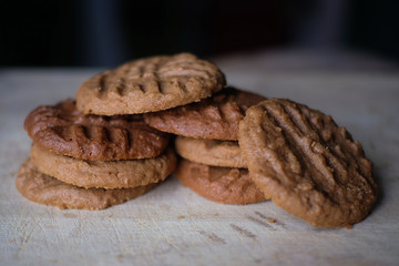 Homemade Peanut Butter Cookies and cookie bited on Light Wooden table with dark background