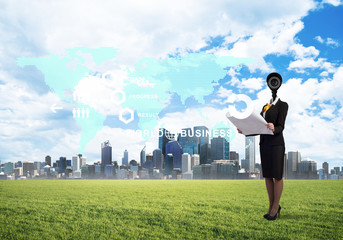 Camera headed woman standing on green grass against modern cityscape