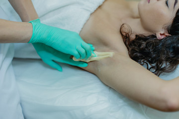 Sugaring. The girl beautician deals on sensitive areas of hands sugar wax.