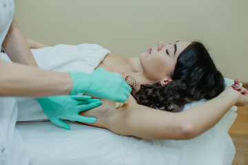 Sugaring. The girl beautician deals on sensitive areas of hands sugar wax.
