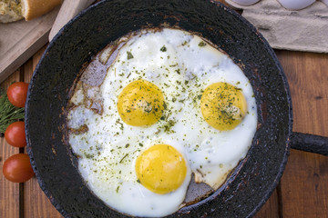 appetizing fried eggs in an old frying pan
